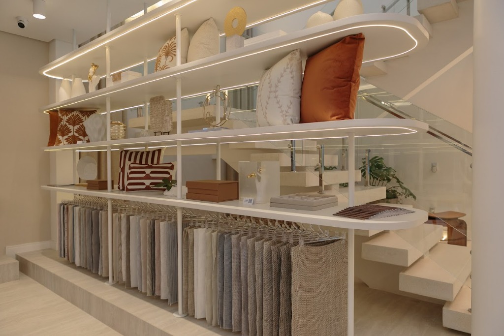 Showroom Criativa Cortinas com estante de mostruários de tecidos e almofadas